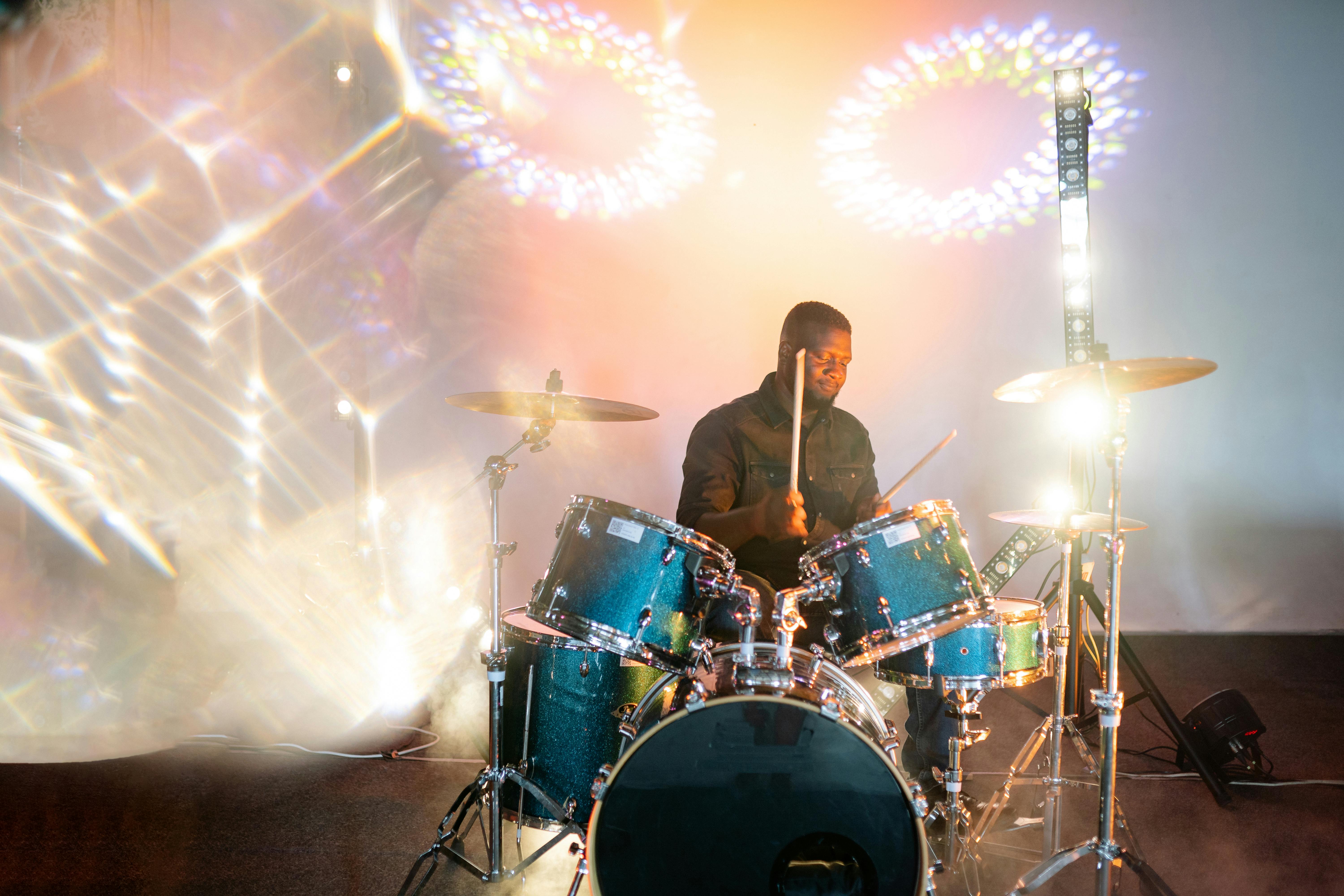 good looking man wearing black polo playing drums