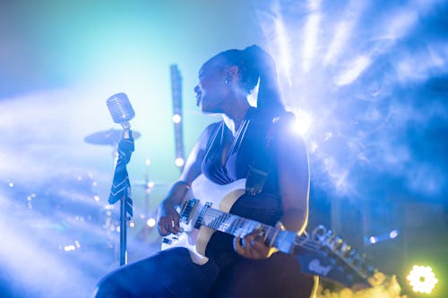 Woman Singing and Playing an Electric Guitar