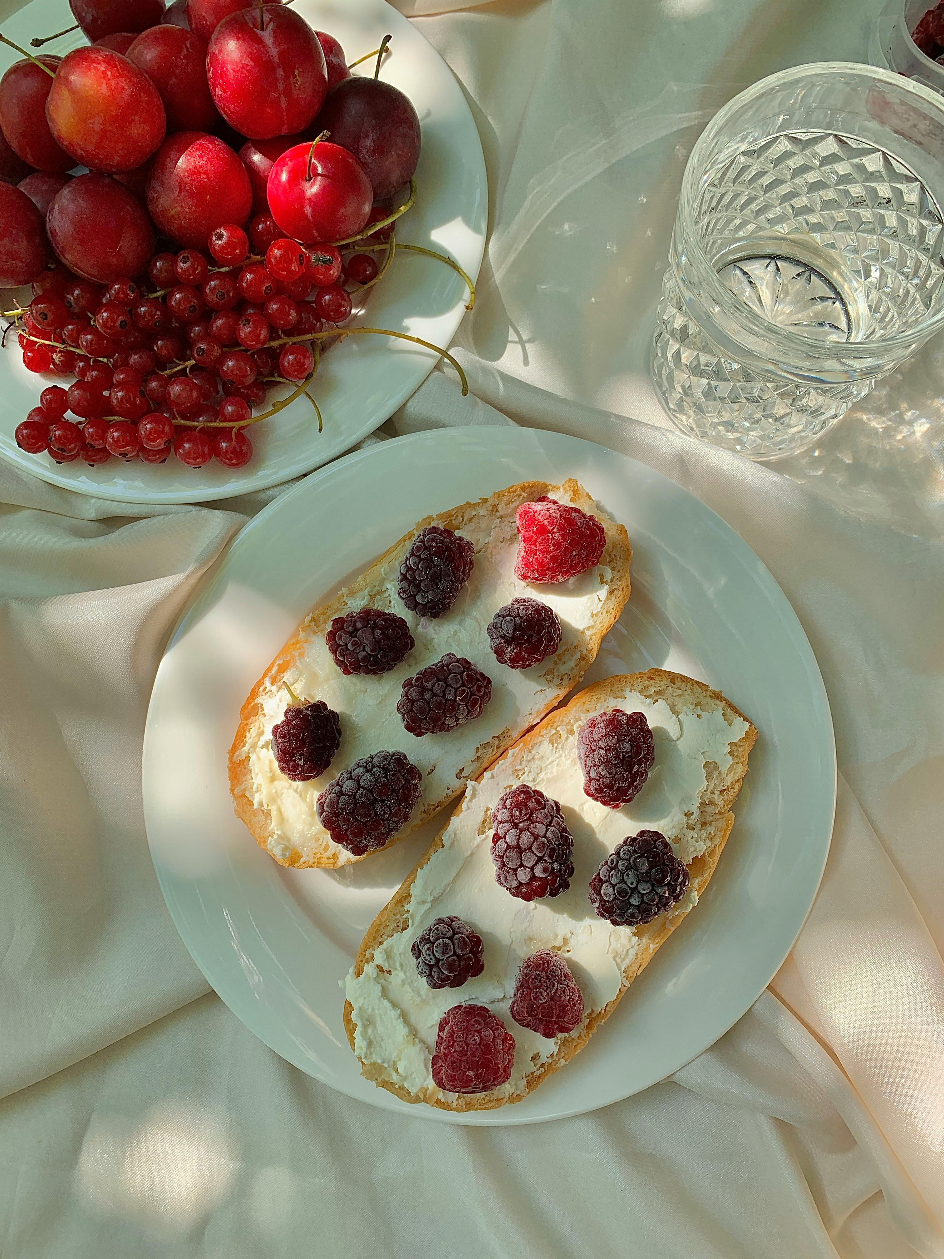 A delicious and artistic arrangement of berries and toast on a ceramic plate, perfect for breakfast.