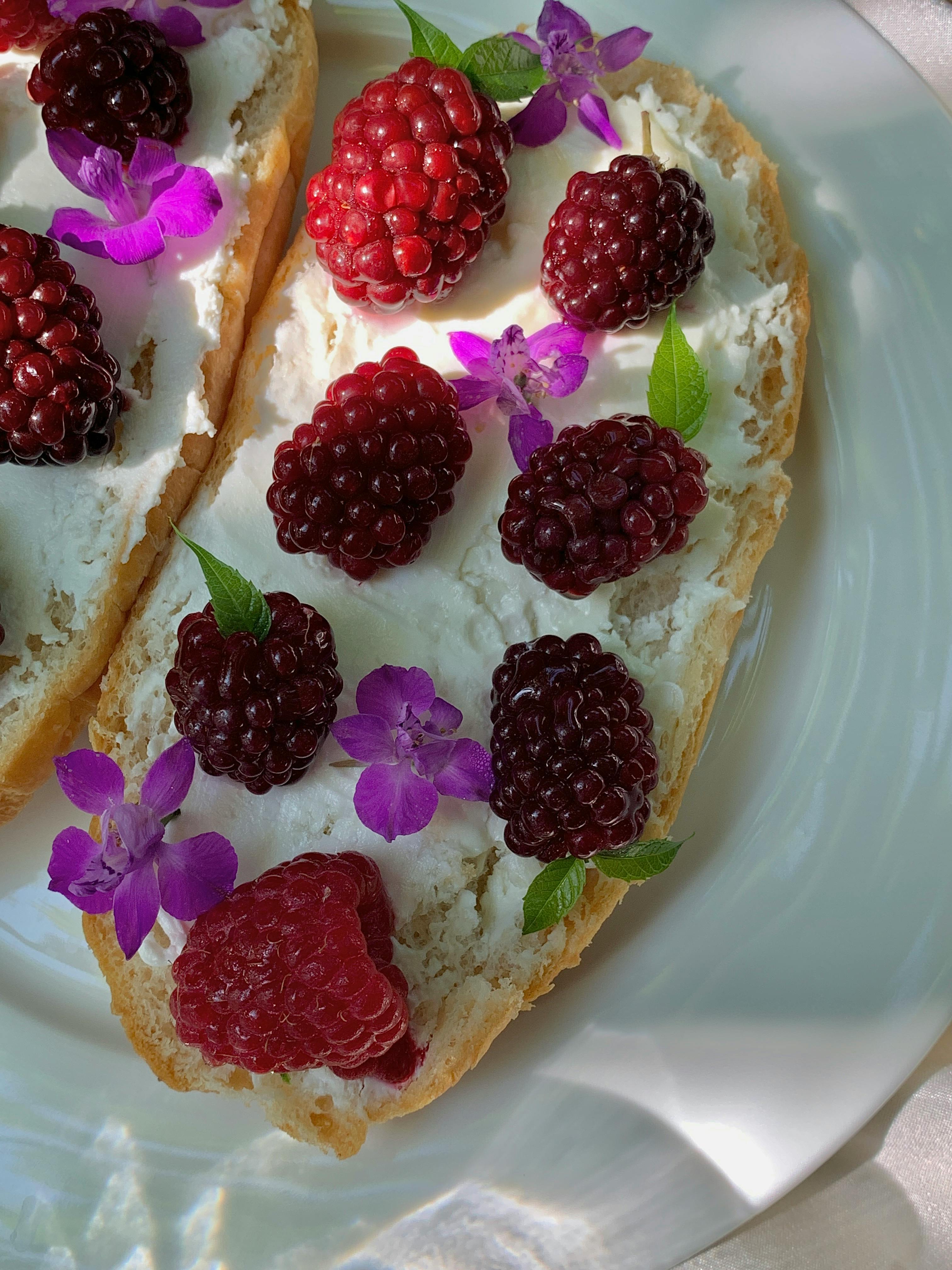 Delicious berry toast garnished with cream and edible flowers for a vibrant breakfast.