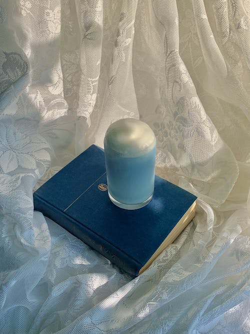 A Blue Book with Drinking Glass on Top