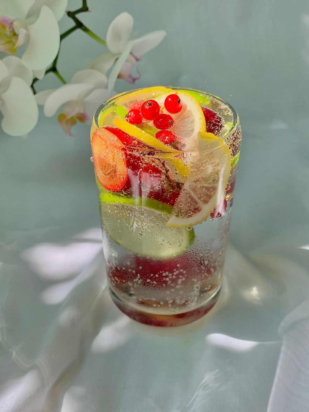 A sparkling citrus drink garnished with red berries