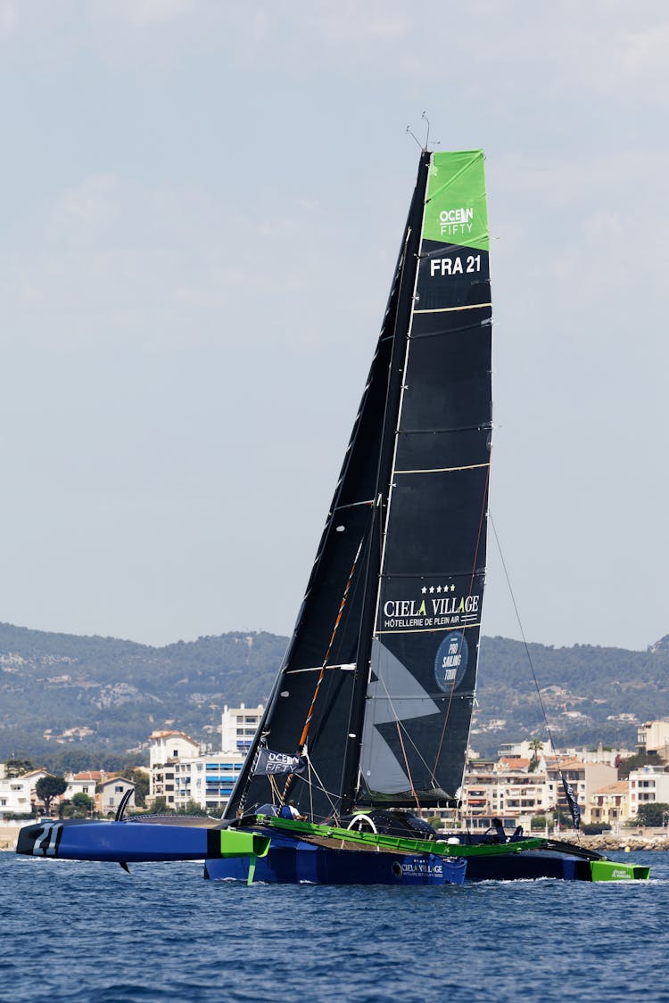 A Blue Catamaran Sailboat Sailing In The Sea