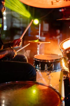 Energetic live performance by a drummer with vibrant stage lights and dramatic ambiance.