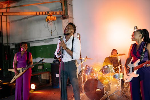 Vibrant band performing live with guitars and drums in a dramatic industrial setting.