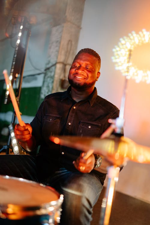 Free A Man Smiling While Playing the Drums  Stock Photo