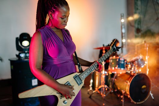 A female musician playing an electric guitar in a vibrant stage setting with colorful lights.