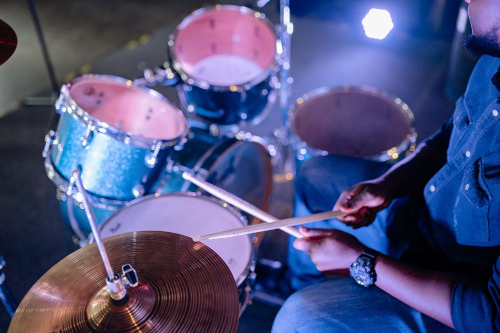 Hands playing the drums with drumsticks