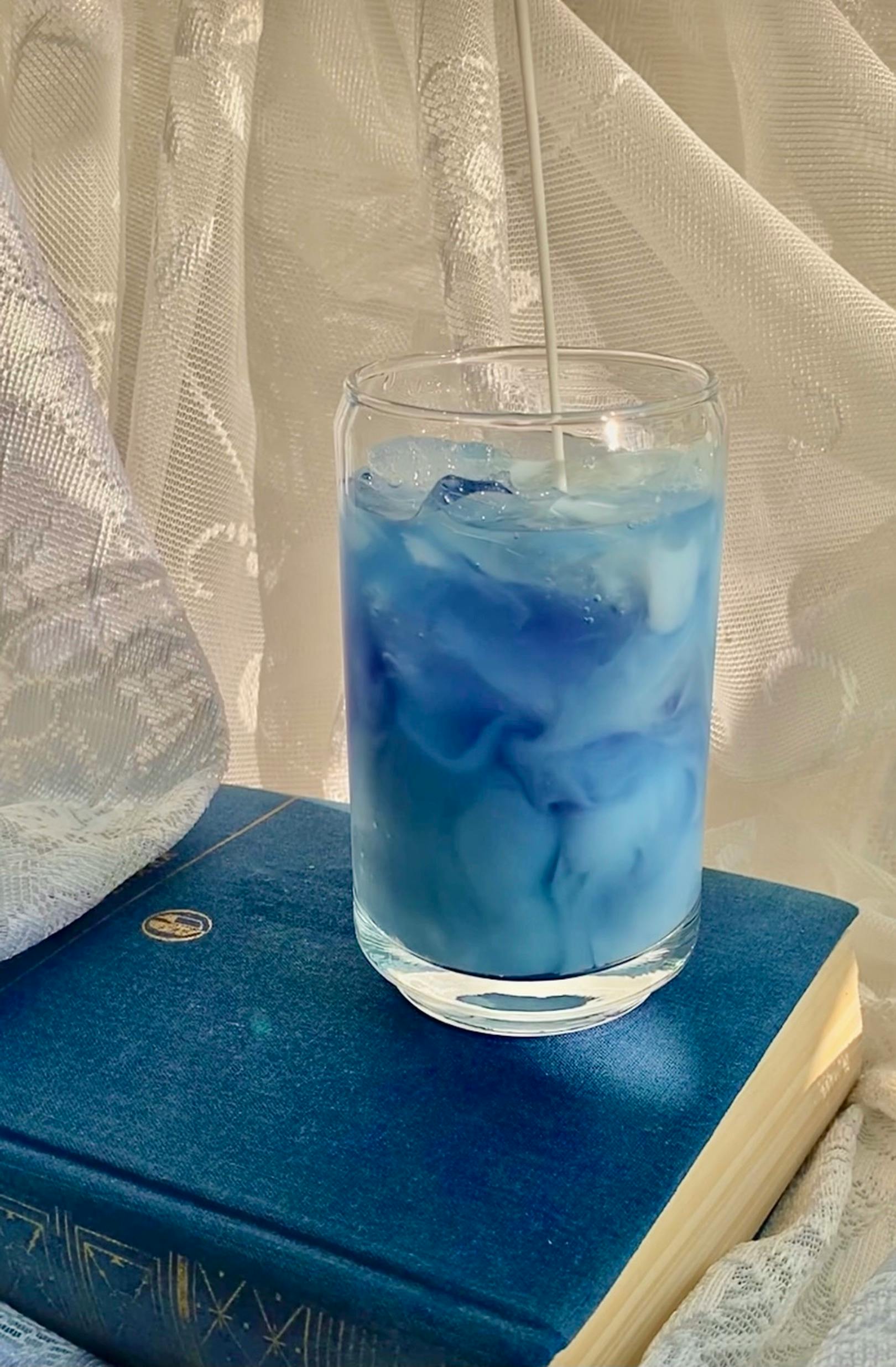 a glass of cold drink on top of a book