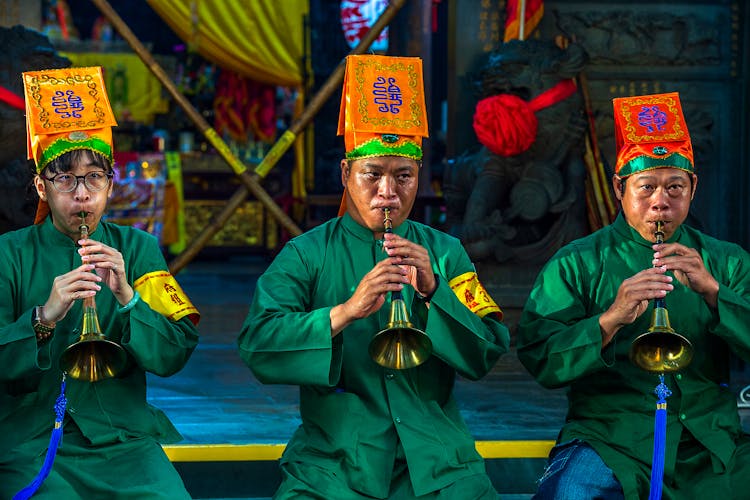 A Group Of Men In Green Long Sleeve Uniform Playing Trumpets