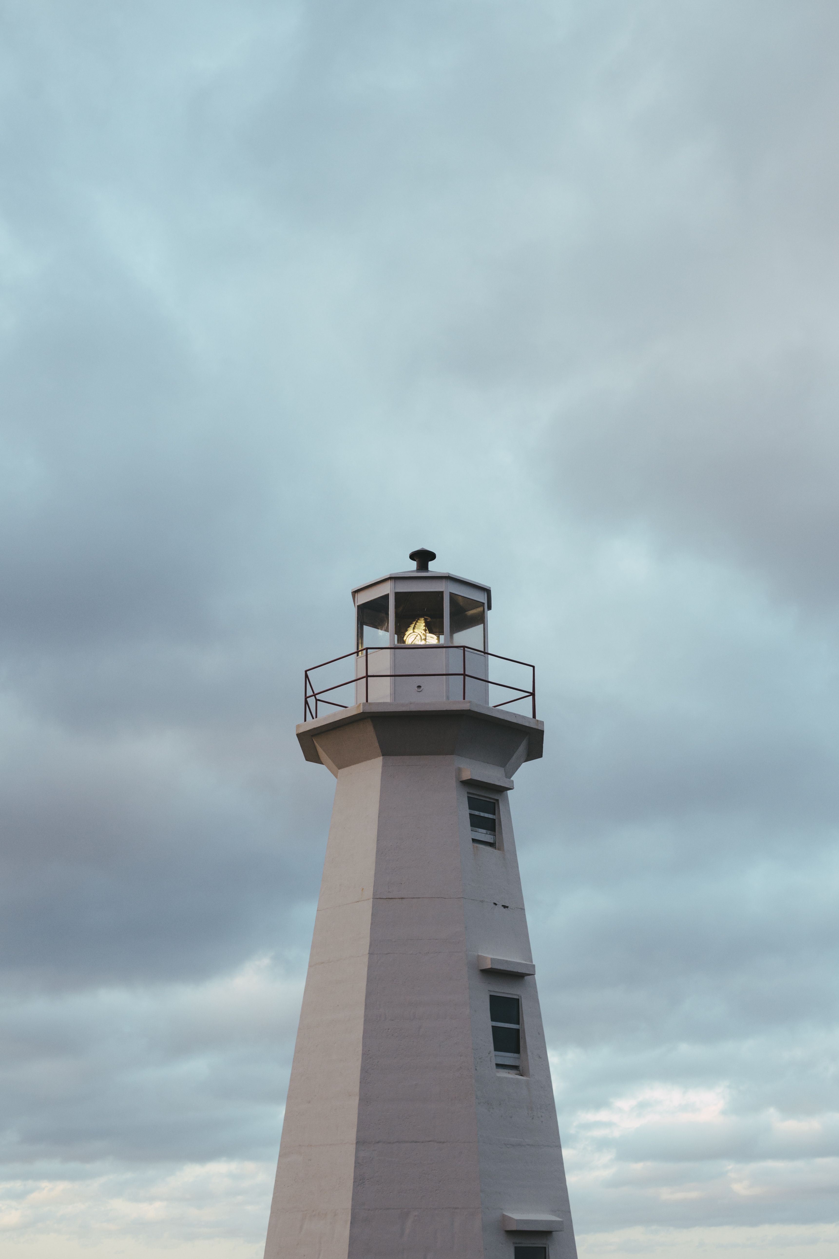 Photo of a White Lighthouse Under a Cloudy Sky · Free Stock Photo