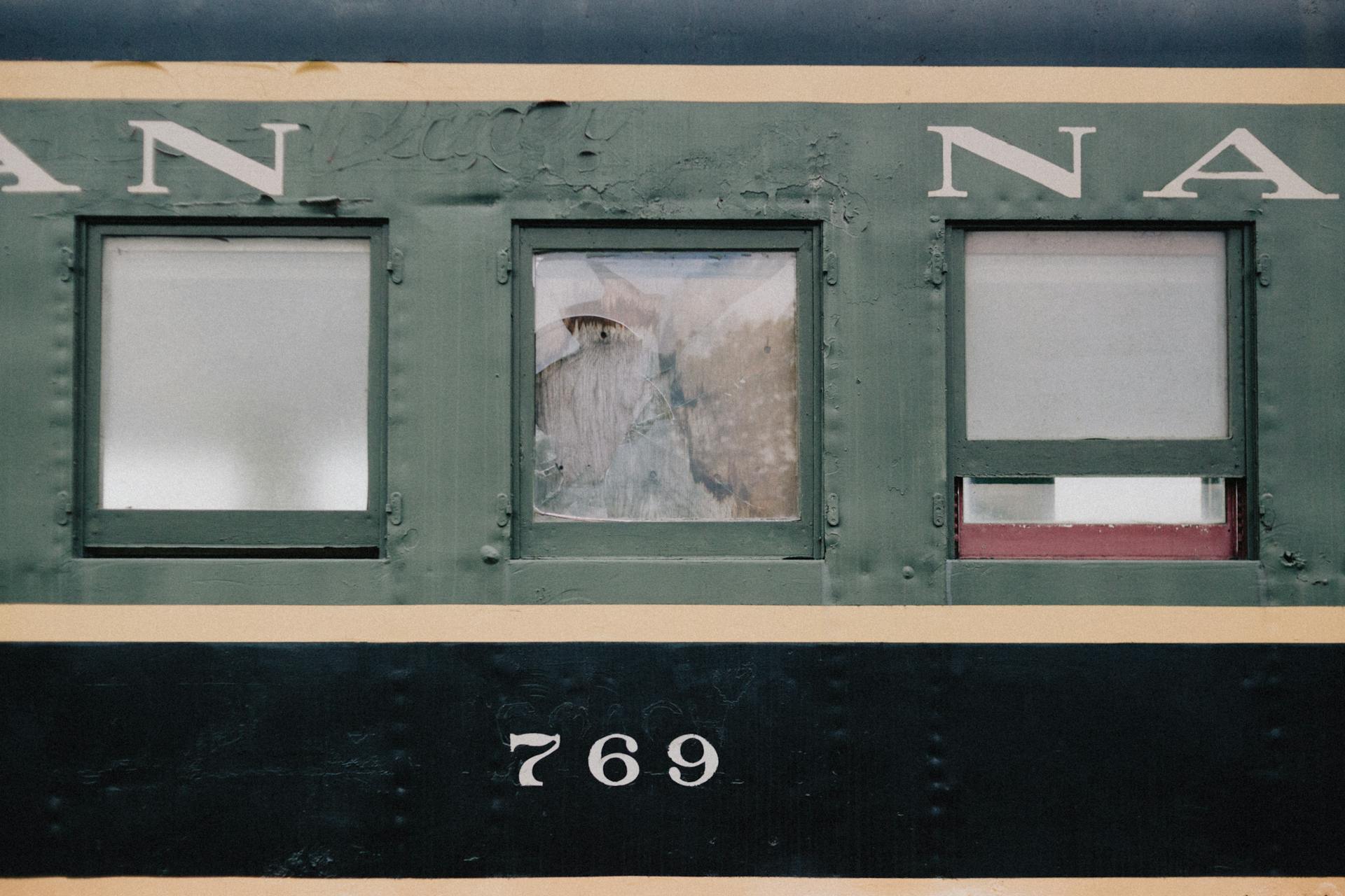 Close-up of a vintage train carriage with green weathered windows and number 769 visible.