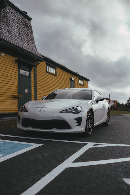 A White Sports Car Parked outside a Building