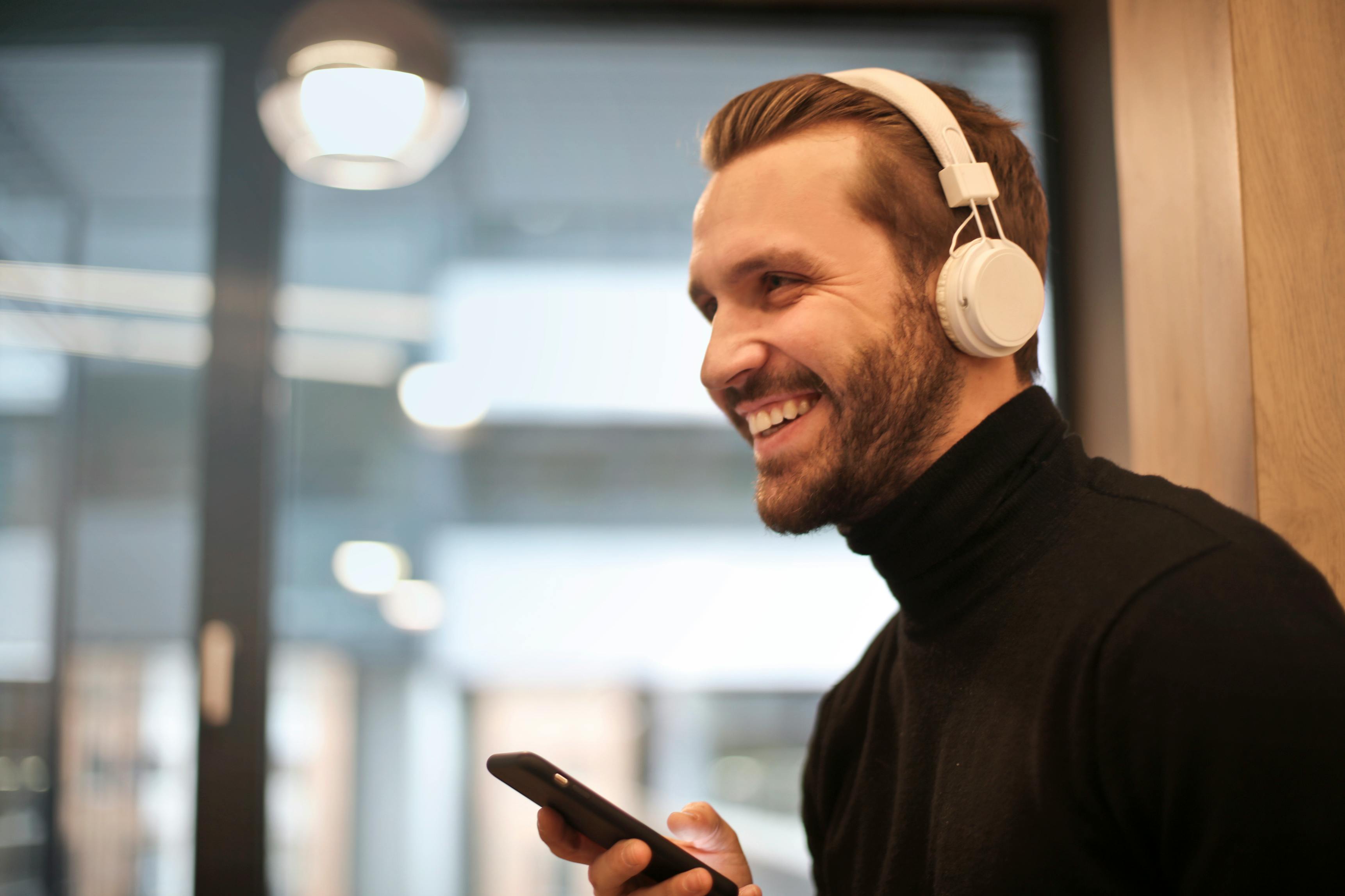 homem asiático usando fones de ouvido brancos toca piano e canta