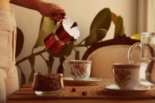 Free Photograph of a Person's Hand Pouring Coffee from a Moka Pot Stock Photo