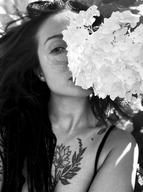 Free Monochrome Photograph of a Woman Behind Flowers Stock Photo