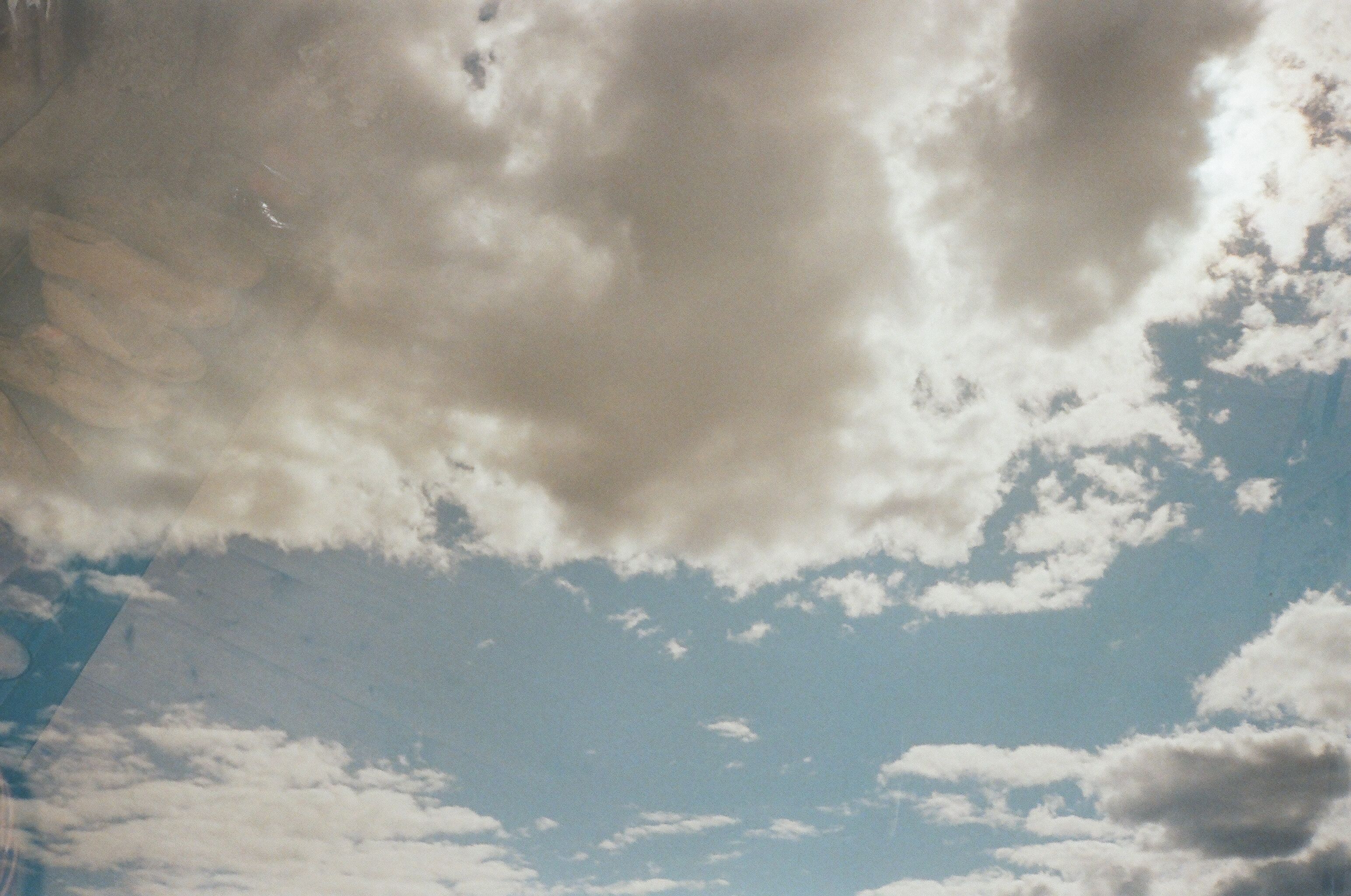 High-altitude view of a cloudy sky with sunlight peeking through, creating a dramatic cloudscape.