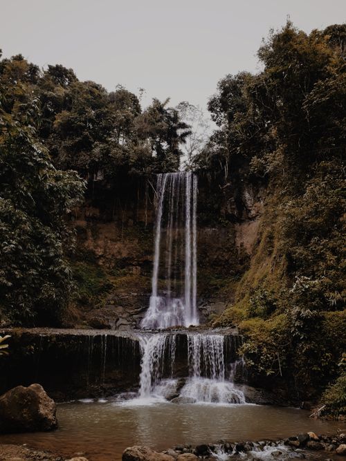 Free A stunning waterfall cascades through lush forest, showcasing nature's beauty and tranquility. Stock Photo