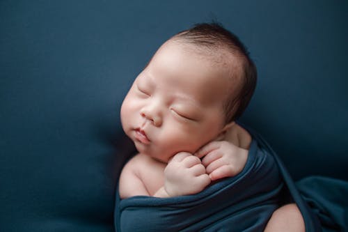 Free A Cute Baby Sleeping Covered in Blue Blanket Stock Photo