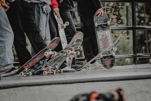 Free Skateboarders gather at a skatepark, ready to ride with their skateboards poised for action. Stock Photo