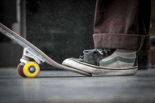 Free A Person Stepping on It's Skateboard Stock Photo