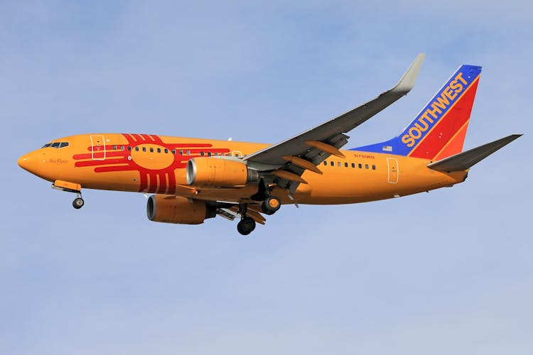 An Orange Passenger Plane In The Sky