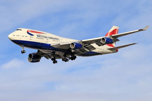 Free A British Airways Boeing 747 aircraft flying against a blue sky. Stock Photo