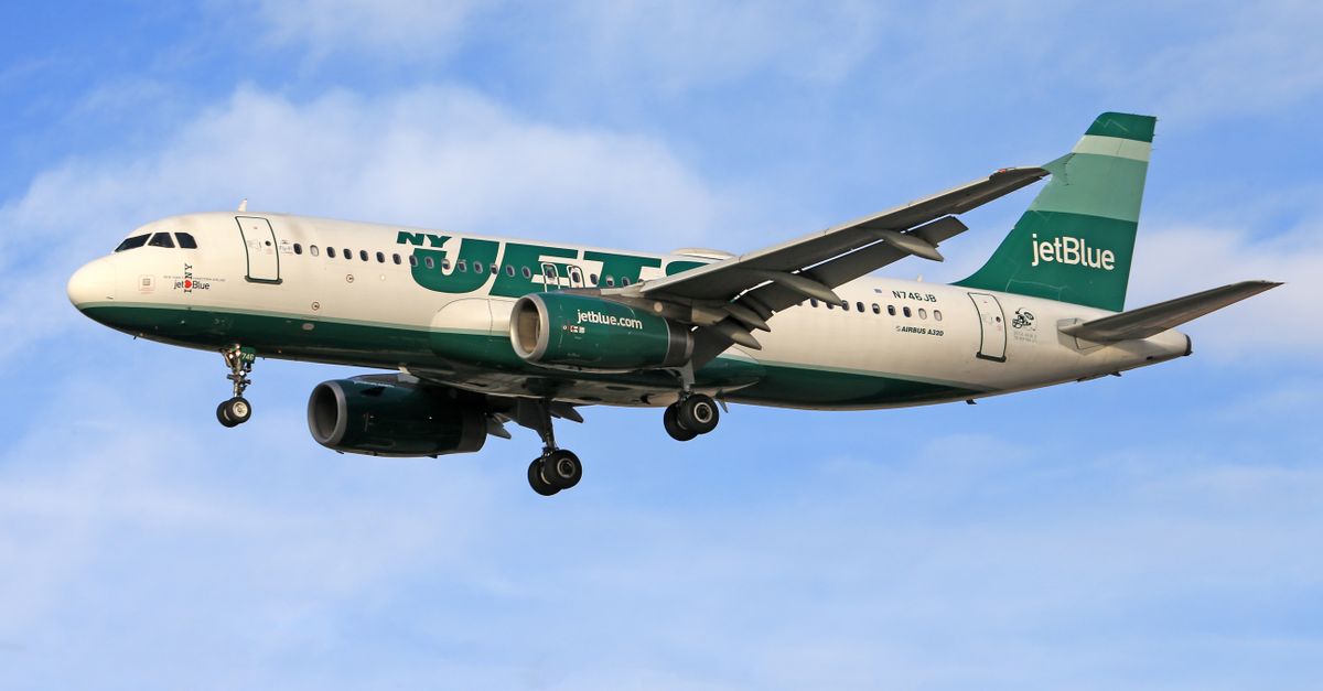 Photo by Jeffry Surianto JetBlue Airbus A320 in flight with NY Jets livery against a clear blue sky.