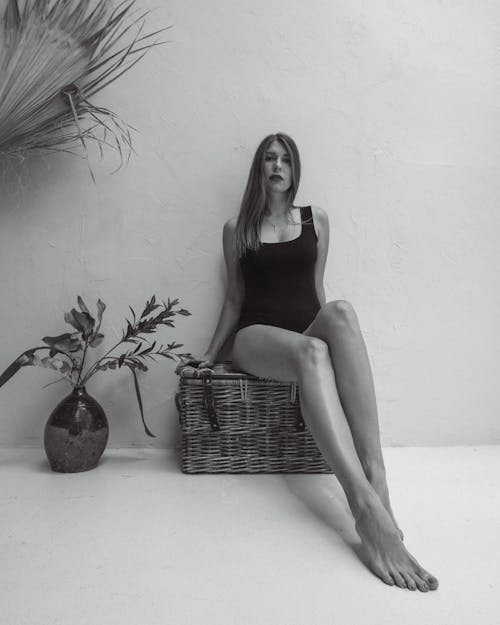 Woman in a Swimsuit Sitting on a Woven Basket