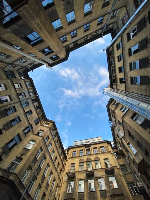 Free Dramatic upward view of historic urban buildings against a blue sky, showcasing architectural design. Stock Photo