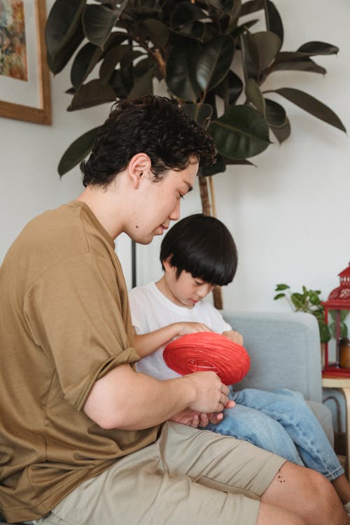 A Ma Sitting on the Couch with His Child