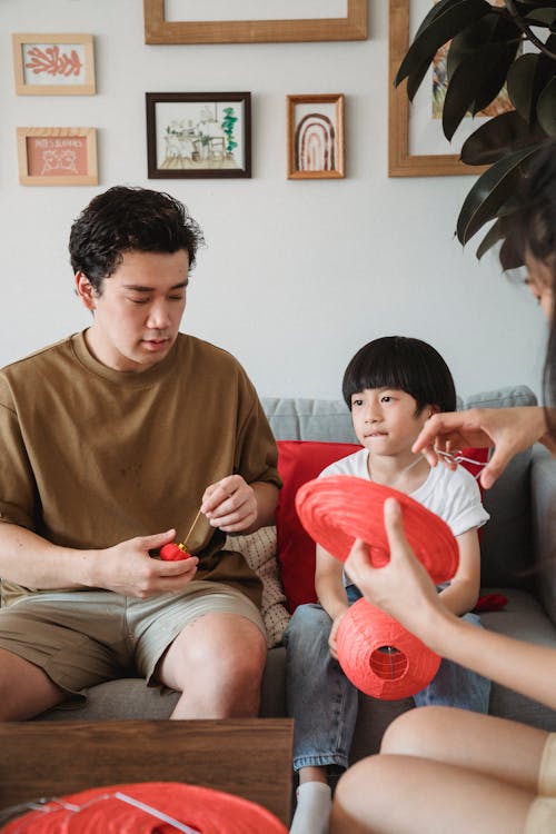 A Man Sitting with His Child while Holding a Lanterns