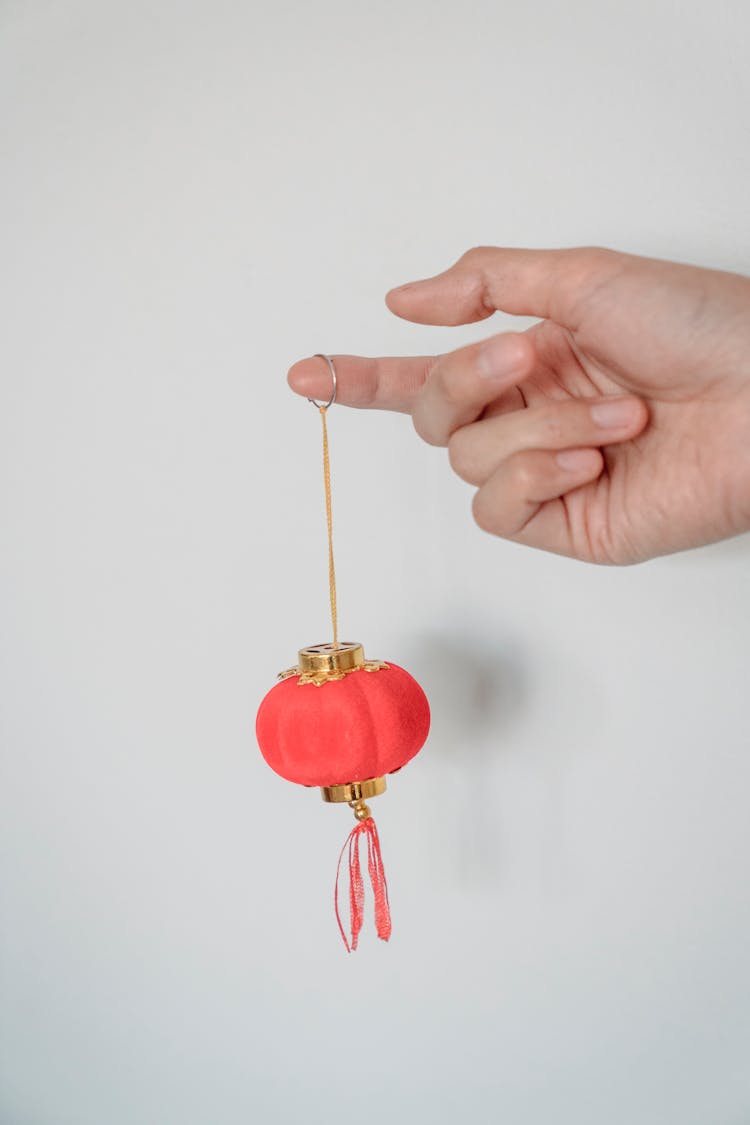 Person Holding A Small Hanging Lantern