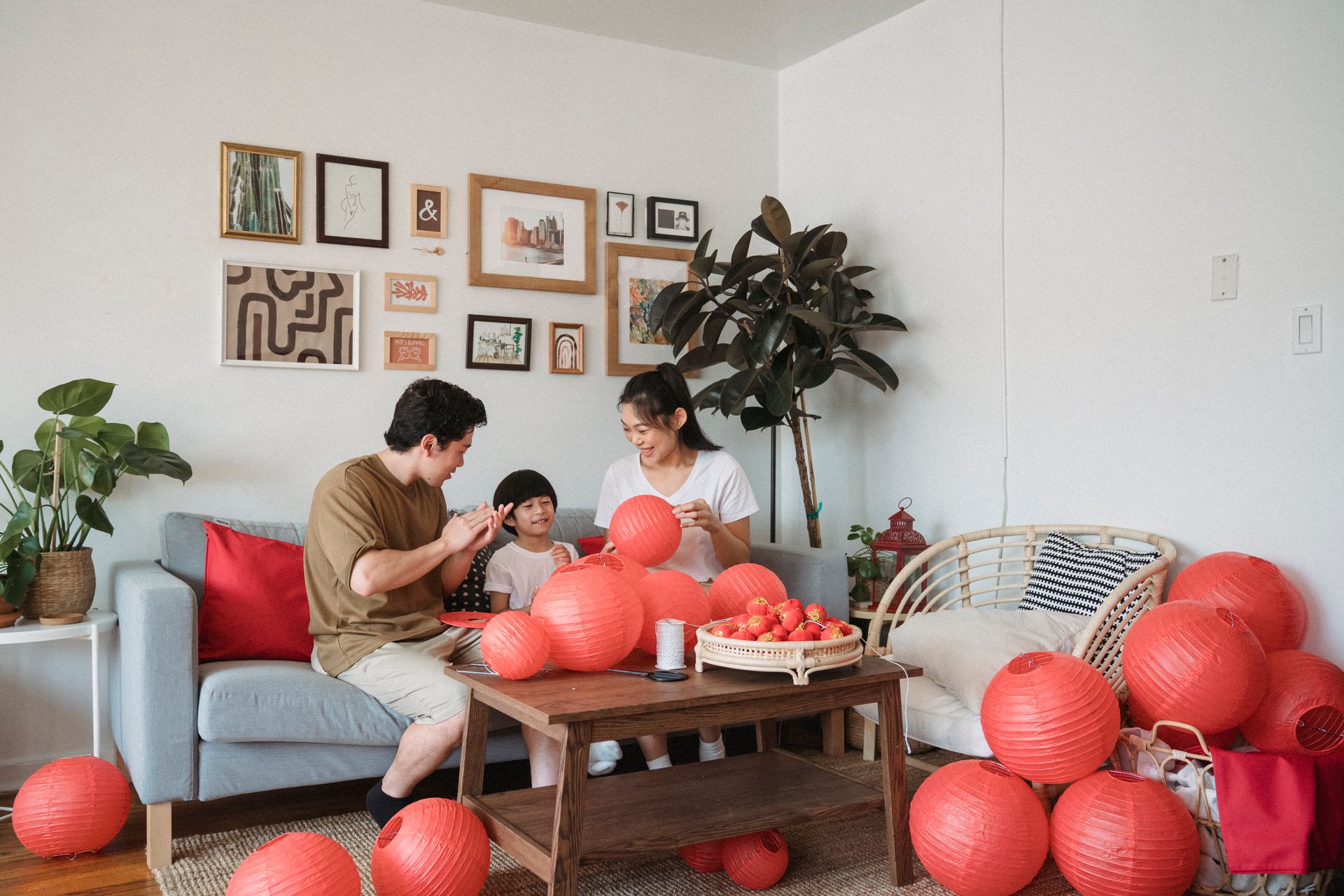 Family gathering indoors decorating with red lanterns, creating a warm and festive atmosphere.
