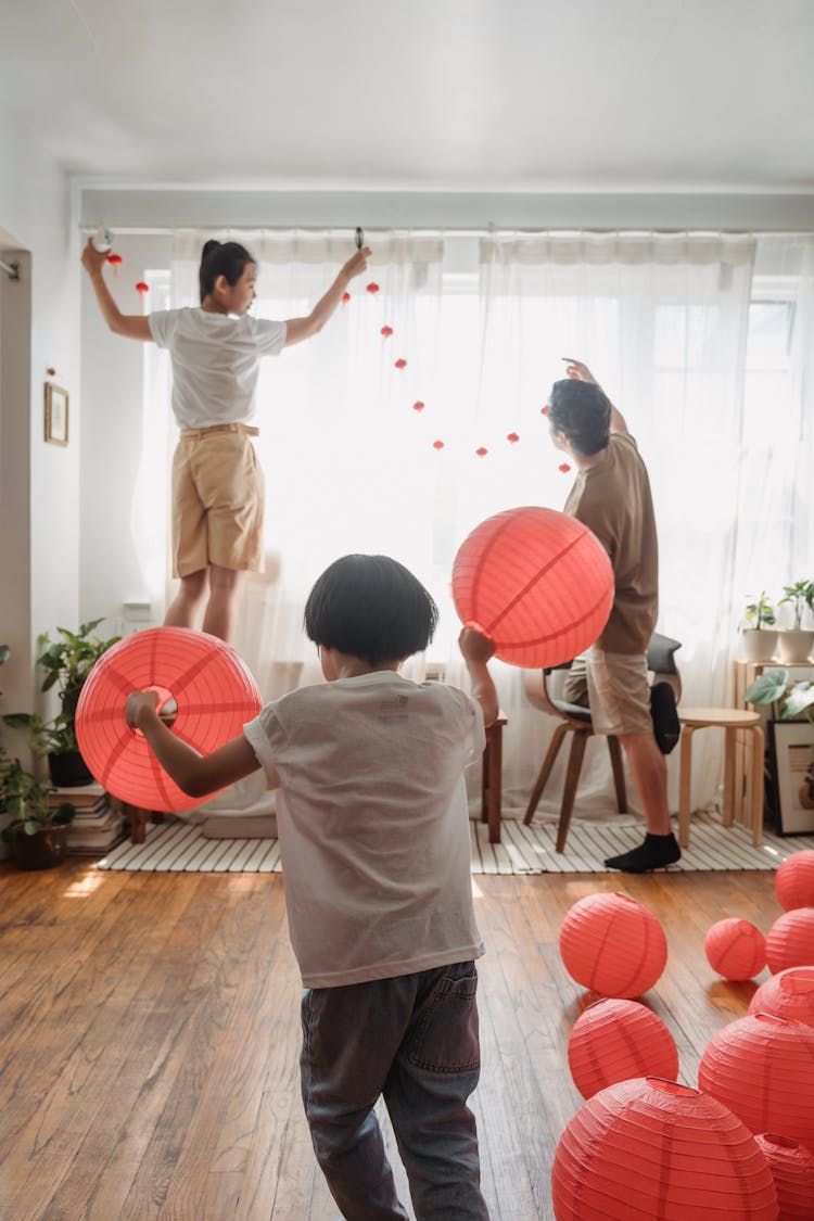 A Child Playing With Red Chinese Lanterns