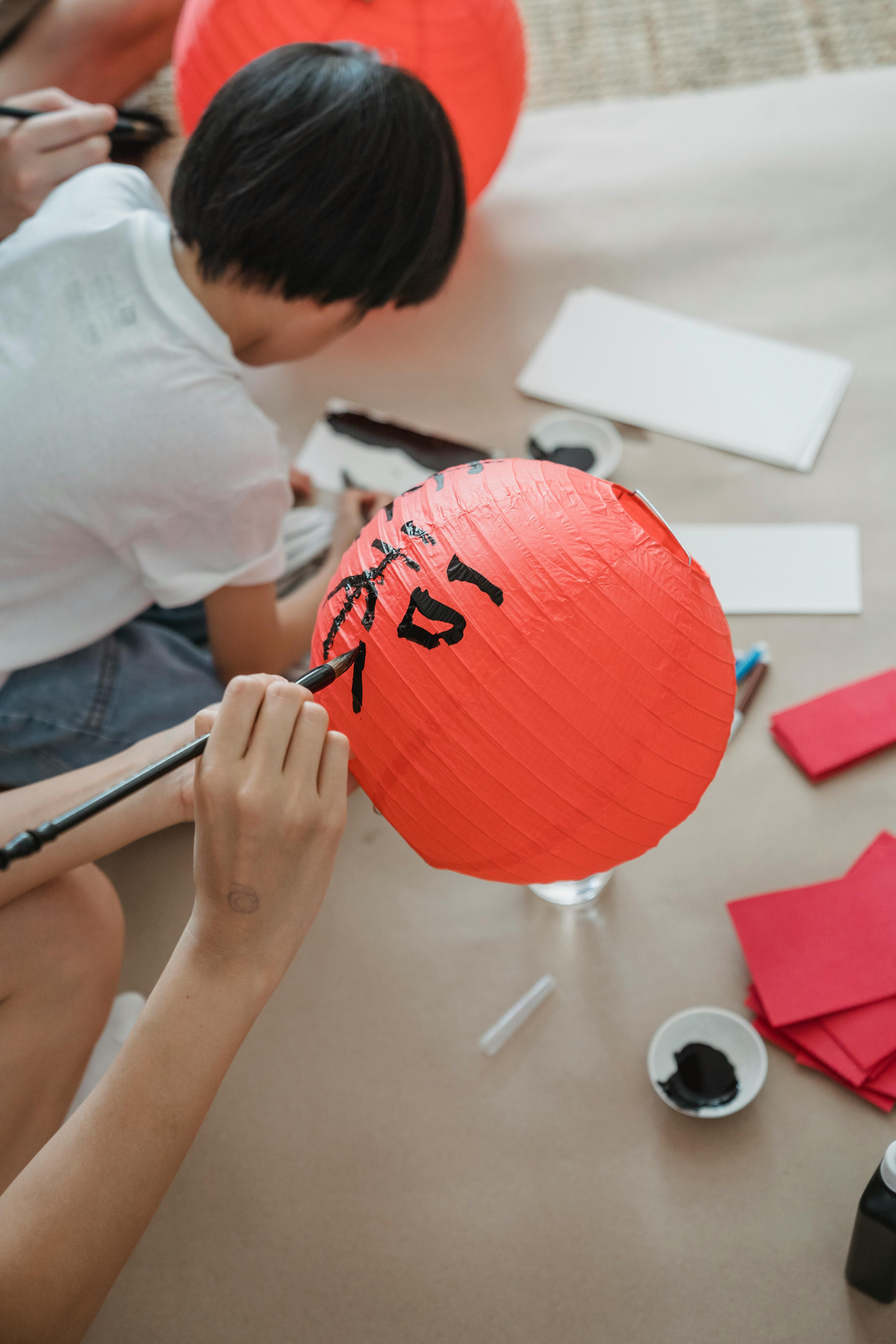 person holding a red paper lantern