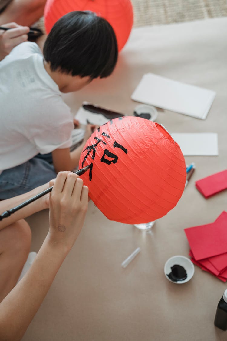 Person Holding A Red Paper Lantern