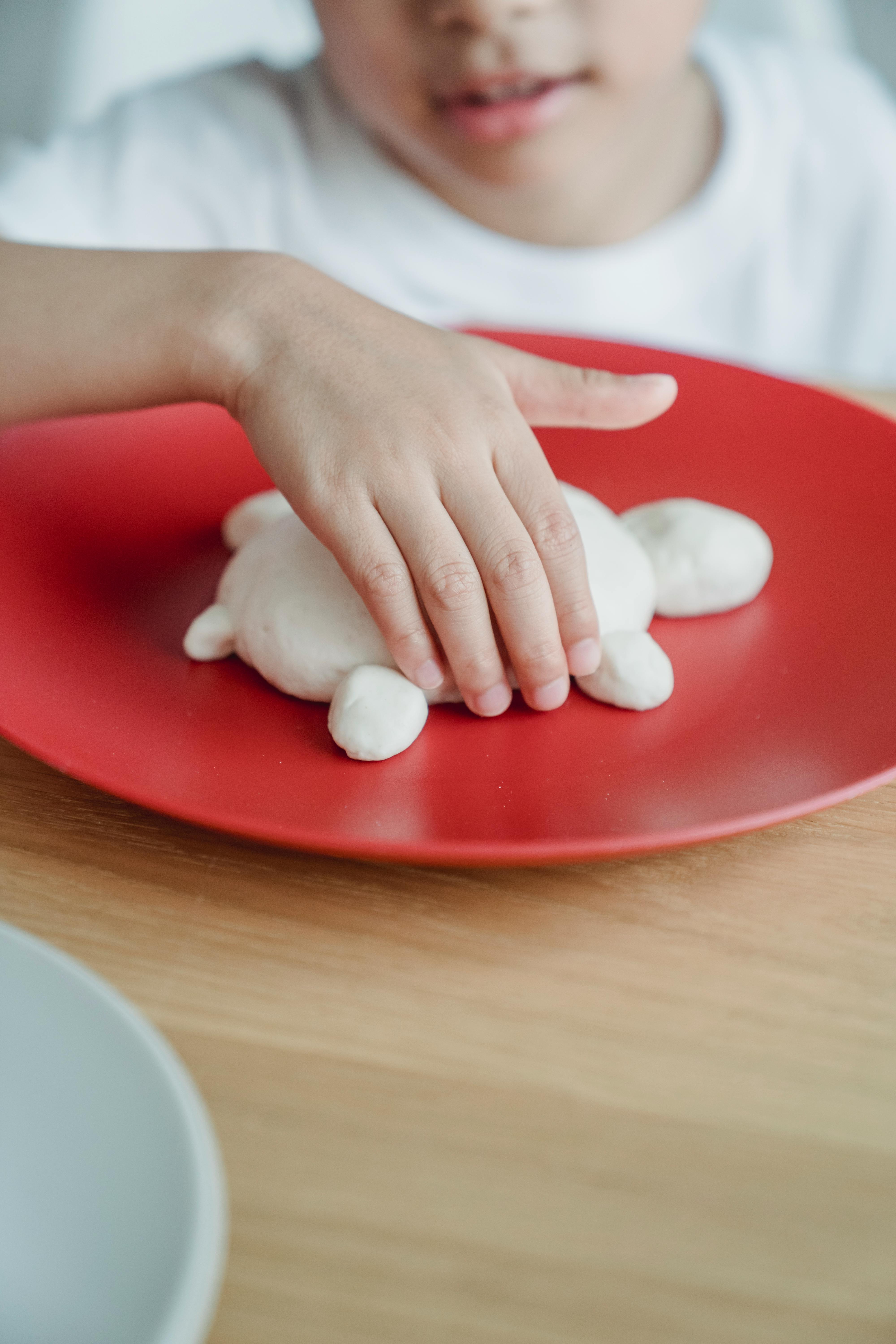 Touching of Dough placed in a Plate · Free Stock Photo