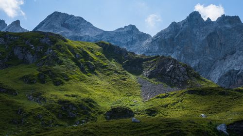 Free Explore the serene beauty of lush green mountains under a clear blue sky. Perfect for nature lovers. Stock Photo