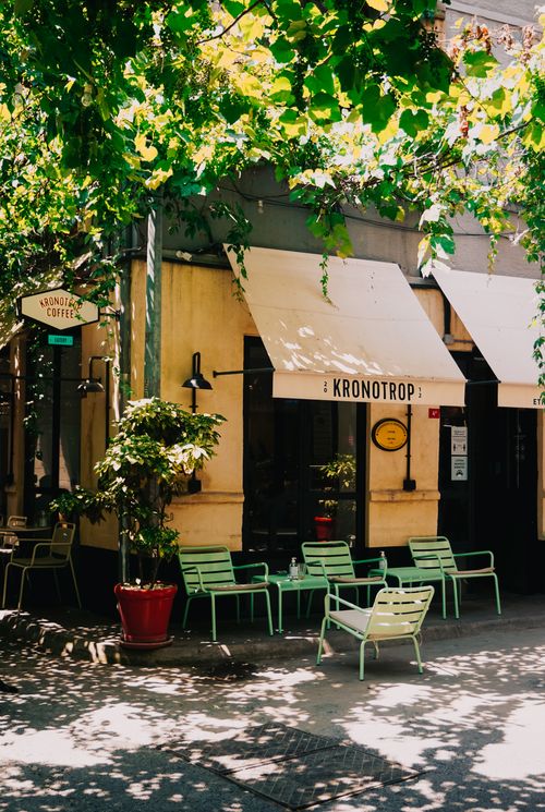 Free Outdoor view of a quaint coffee shop in İstanbul with green chairs and lush surroundings. Stock Photo