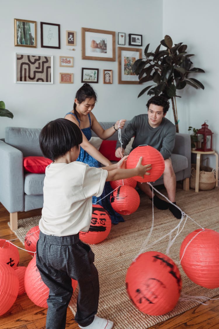 Family Fixing The Strings Of Hanging Lanterns