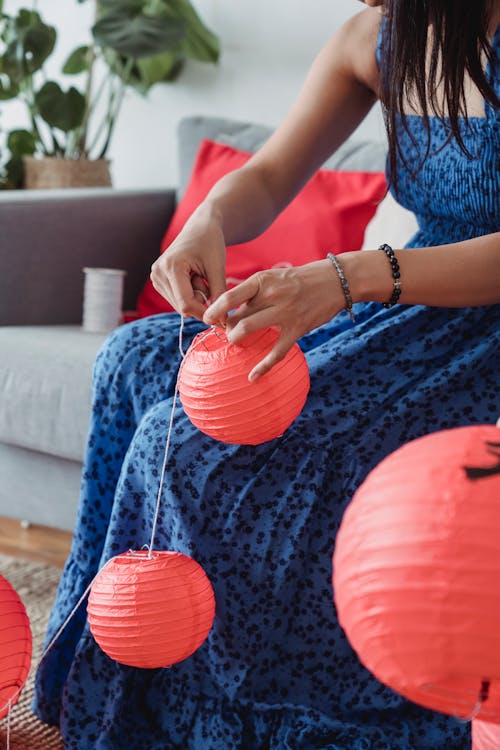 Woman Holding the Strings of Red Hanging Lanterns