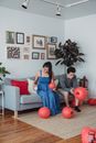 Man and Woman Fixing Hanging Lanterns Together in the Living Room