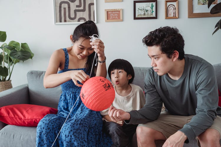 Family Fixing Hanging Lanterns Together