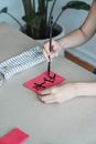 A Person Writing on a Piece of Paper Using a Brush and Black Ink