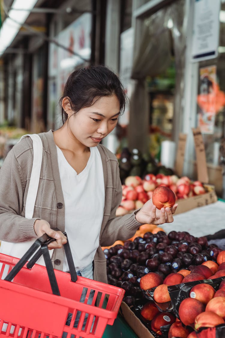 Woman In Long Sleeve Cardigan Holding Shopping Basket