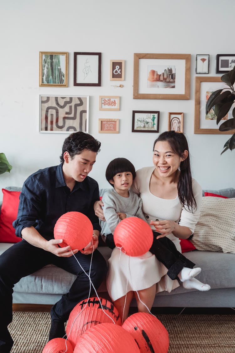 A Family Sitting On A Couch