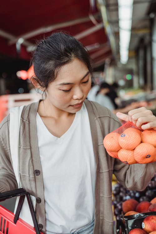 A Woman Holding a Bag of Oranges