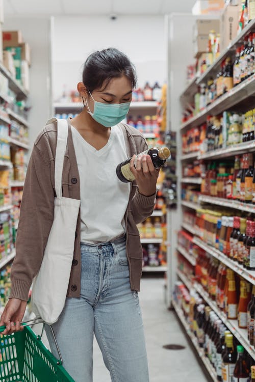 consumers Free A Woman Wearing Face Mask Holding a Sauce Bottle Stock Photo