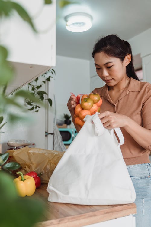 Kostenloses Stock Foto zu asiatische frau, drinnen, festhalten